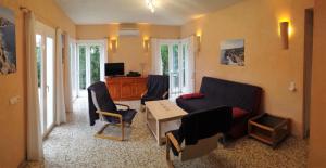 uma sala de estar com um sofá, cadeiras e uma mesa em Finca Ses Rotes em Cala Llombards