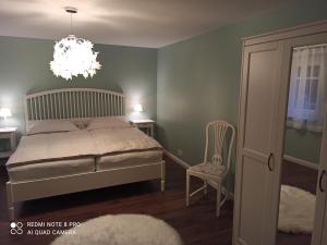 1 dormitorio con cama y lámpara de araña en Schöne 77qm Wohnung in gehobener Lage direkt am Wald, en Rodenbach