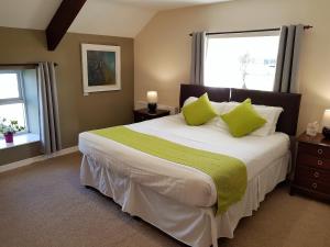 1 dormitorio con 1 cama grande con almohadas verdes en Spacious 3-Bedroom 3-bathroom country cottage, en Haverfordwest
