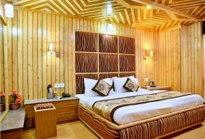 a bedroom with a bed and a wooden wall at Hotel Chaman Palace in Shimla
