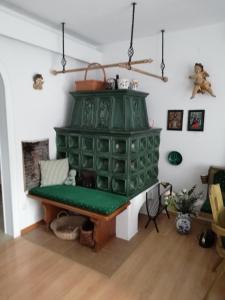 una chimenea verde en la sala de estar con un banco verde en Haus Aschau, en Bad Ischl