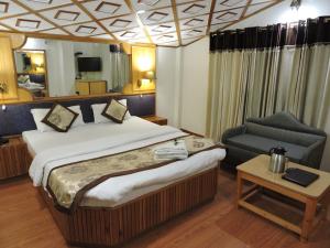 um quarto de hotel com uma cama e uma cadeira em Hotel Chaman Palace em Shimla