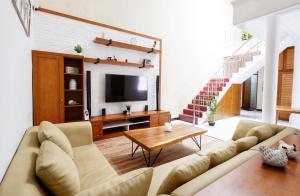 a living room with a couch and a tv at Andromeda Home Stay Yogyakarta Malioboro in Bantul
