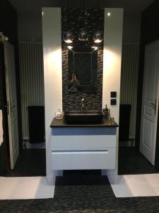 a bathroom with a sink and a person in a mirror at Château de La Feuilleraie in Saint-Leu-la-Forêt