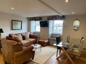 a living room with a couch and a glass table at Monmouth House Apartments, Lyme Regis Old Town, dog friendly, parking in Lyme Regis