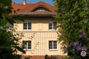 una casa amarilla con techo rojo en Villa Dohna - Apartment Wedelstam en Leipzig