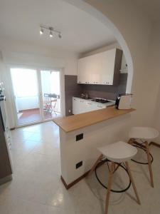a kitchen with a counter and two stools in it at De Dominici's House in Castel di Sangro