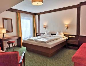 A bed or beds in a room at Hotel Stockerwirt Még 36 kép