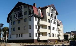 a large white building with a red roof at Apart Hotel 38 (95m2) in Polanica-Zdrój