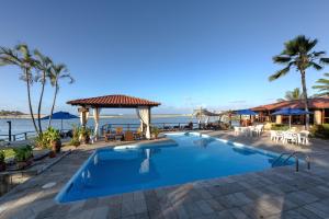 a swimming pool with a view of the ocean at Pousada Villa do Sol in Genipabu