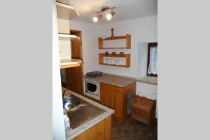 a small kitchen with wooden cabinets and a sink at Chalupa u Kolčavy in Volenice