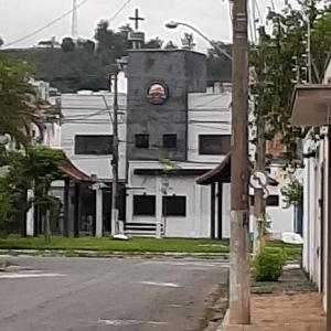 un edificio bianco con una torre dell'orologio su una strada di Pousada Maria Maria Próximo ao Santuário Nacional a Aparecida