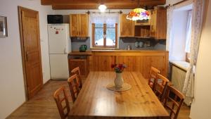 a kitchen with a wooden table with a vase of flowers on it at Ubytování Samotín in Sněžné