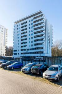 rząd samochodów zaparkowanych przed dużym budynkiem w obiekcie Apartament 5k Szczecin w Szczecinie
