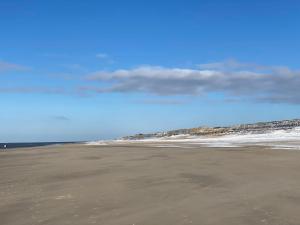 a sandy beach with the ocean in the background at Skriien Mö TOP-Fewo 4 Sterne 5 Min zum Strand Balkon 2 SZ TG Zentrum in Westerland