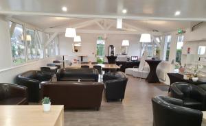 una sala de espera con mesas y sillas de cuero en Budget Hotel Melun Sud - Dammarie Les Lys en Dammarie-lès-Lys