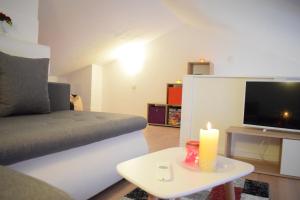 a living room with a couch and a candle on a table at Apartment Golden Sun in Vir