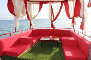 a living room with a red couch and a table at Nuweiba Club Resort in Nuweiba