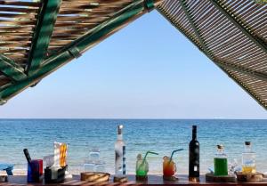 un tavolo con bottiglie e bicchieri sulla spiaggia di Nuweiba Club Resort a Nuweiba
