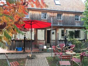 une terrasse avec des chaises et un parasol en face d'une maison dans l'établissement Pension Elbkiosk, à Kleinzadel