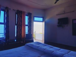 a bedroom with a bed and a large window at Apical Resort in Bhīm Tāl