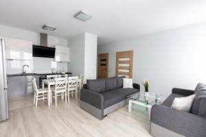 salon z dwiema kanapami i kuchnią w obiekcie Apartament 5k Szczecin w Szczecinie