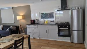 a kitchen with a stainless steel refrigerator and a table at Chalet Op De Veluwe # Berk in Putten