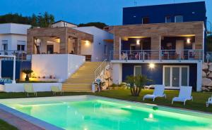 a villa with a swimming pool in front of a house at Casa Azul in Castellammare del Golfo