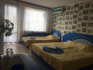 een hotelkamer met drie bedden en een tafel bij Къща за гости КАТИ in Kiten