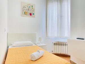 una camera da letto con un letto e un asciugamano sopra di CH Rayuela a Madrid
