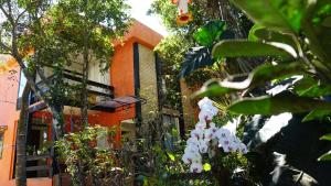 een oranje gebouw met witte bloemen ervoor bij Casa Di Gaya in Cabo Frio