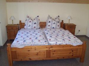 a wooden bed in a bedroom with two night stands at Zur-alten-Schmiede-II-Haus-II in Boltenhagen