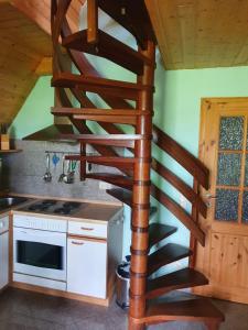eine hölzerne Wendeltreppe in einer Küche mit einem Herd in der Unterkunft Zur alten Schmiede II Haus II in Boltenhagen