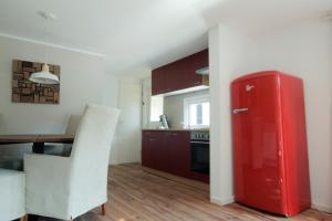 eine Küche mit einem roten Kühlschrank und einem Tisch in der Unterkunft Chalet Op De Veluwe # Eiken in Putten