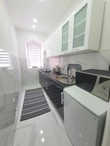 cocina blanca con fregadero y microondas en Apartman DIN en Travnik