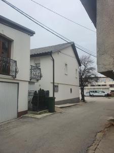 a white house with a gate and a street at Apartman DIN in Travnik