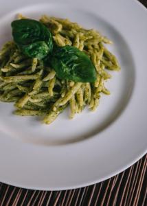 a plate of pasta with greens on top at Mami Sabaudia Hotel in Sabaudia