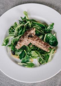 a plate of greens with a piece of meat on it at Mami Sabaudia Hotel in Sabaudia