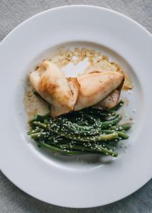a plate of food with chicken and green beans at Mami Sabaudia Hotel in Sabaudia
