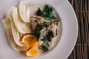 a white plate of food with apples and oranges at Mami Sabaudia Hotel in Sabaudia