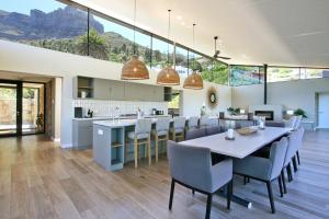 an open kitchen and dining room with a table and chairs at Villa Frangipani in Cape Town