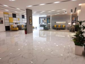 a lobby with a large marble floor and yellow chairs at الأجنحة التنفيذية للشقق المخدومة - اقتصادي in Riyadh