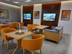 a waiting room with tables and chairs and paintings at Executive Suites in Riyadh