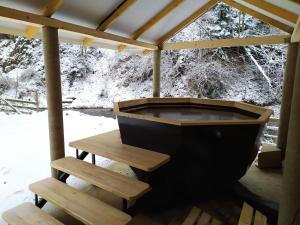 a bath tub in a gazebo with a bench at Lisnyi in Mizhhirʼʼya