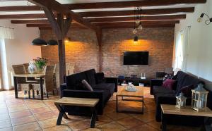 a living room with couches and a brick wall at Na Skraju Warmii in Barczewo