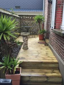 a wooden walkway leading to a patio with potted plants at Chambre D'hôte Villa Maurice in Étretat
