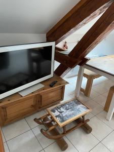 sala de estar con TV grande y mesa en Appartement F2 proche La Bresse en Basse-sur-le-Rupt