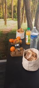 - une table avec du pain, des oranges et une bouteille d'eau dans l'établissement Le Saint Vincent, à Apremont