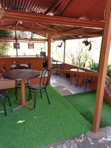 un patio con mesa, sillas y césped en ApartHotel Villa Pacande en Alajuela