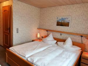 にあるGasthaus Pflugのベッドルーム1室(白いシーツと枕のベッド1台付)